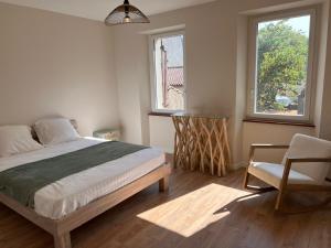 - une chambre avec un lit, une chaise et une fenêtre dans l'établissement Gîte de Pampe Lune & Spa, à Pampelonne
