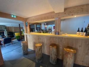 un restaurante con bar con taburetes de madera en RestAuberge La Reine Meije en La Grave