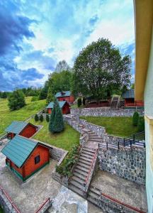 a home with a stone wall and a smallshed at Motel Krstac in Mojkovac