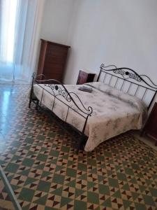 una camera con un letto in metallo e un pavimento a scacchi di Don Aniello Alloggio Turistico a Sulmona