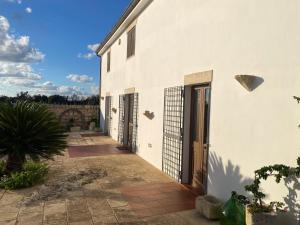 a white building with doors on the side of it at Agriturismo Masseria Saittole in Carpignano Salentino +32 photos