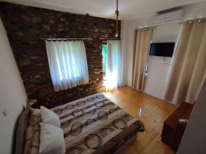 a bedroom with a bed and a stone wall at House of Poposka Kuka in Bitola
