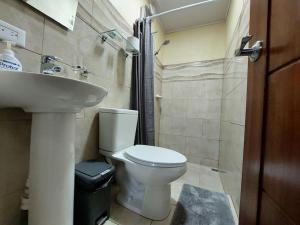 y baño con aseo y lavamanos. en Airport SJO Residence - Edward & Familia Inn, en Alajuela