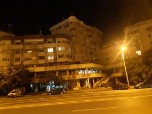 un grand bâtiment avec un éclairage de rue la nuit dans l'établissement Apartament in centrul Iasului (Lapusneanu), à Iaşi