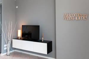 - un salon avec une télévision sur un meuble blanc dans l'établissement APARTMENTS VALPOLICELLA: RESIDENZA OLIVO, à Fumane