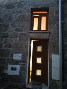dos ventanas en el lateral de un edificio con una puerta en Casa da Gracita, en Pereira