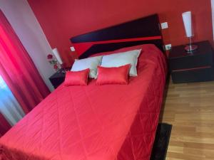 a bedroom with a red bed with two red pillows at Casa da Gracita in Pereira