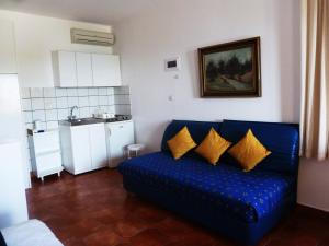 a living room with a blue couch and a kitchen at Milia Bay Hotel Apartments in Milia