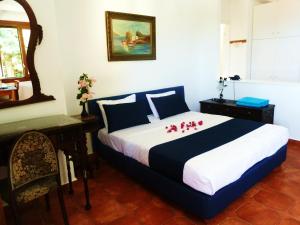 a bedroom with a large bed with red flowers on it at Milia Bay Hotel Apartments in Milia