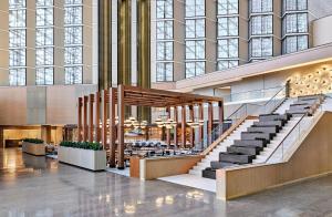 a lobby with stairs in a building with large windows at Omni Austin Hotel Downtown in Austin