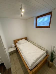 ein kleines Bett in einem Zimmer mit Fenster in der Unterkunft Ferienwohnung Geiger in Sersheim