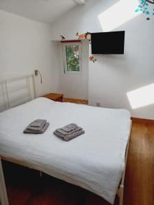 a bedroom with a bed with towels on it at Voyage Hostel - Ensuite Family Rooms with shared kitchen in Douglas