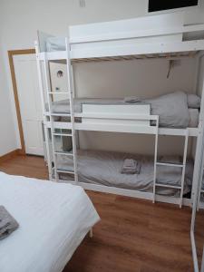 a room with two bunk beds and a television at Voyage Hostel - Ensuite Family Rooms with shared kitchen in Douglas