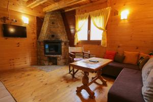ein Wohnzimmer mit einem Kamin in einer Blockhütte in der Unterkunft Lodge Drveni Kutak in Sekulić 