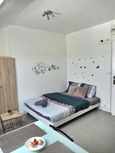 a bedroom with a bed with birds on the wall at Le Lumineux Studio 6 Face Gare Wifi in Évreux