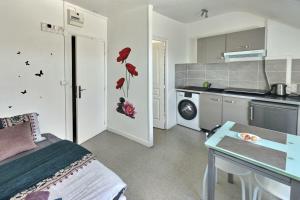 a kitchen with a bed and a table in a room at Le Lumineux Studio 6 Face Gare Wifi in Évreux