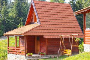 Blockhaus mit rotem Dach und Veranda in der Unterkunft Lodge Drveni Kutak in Sekulić 