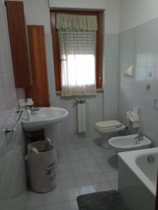 bagno bianco con lavandino e servizi igienici di A casa di Frida & Mika - COMODO PUNTO DI SOSTA - a Civita Castellana