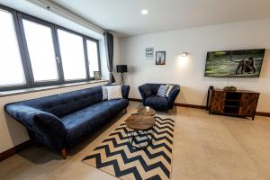 salon z niebieską kanapą i stołem w obiekcie Servus-Apartments Direkt in der City nah am Wasser Netflix w Pasawie