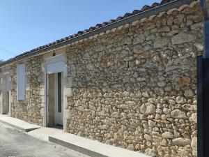 een stenen muur van een gebouw met een deur bij gîte du Laïka in Listrac-Médoc