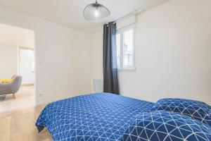 Un dormitorio con una cama azul y una ventana en Appartement lumineux proche Cathédrale en Reims