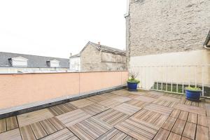 a balcony with a wooden floor and a building at Appartement lumineux proche Cathédrale in Reims +7 photos