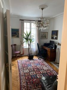 een woonkamer met een bank en een bureau bij Bel Appartement Haussmannien - Gare de Lyon in Parijs