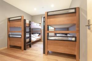 a room with three bunk beds in a room at Bluebird Chalets by The Hakuba Collection in Hakuba