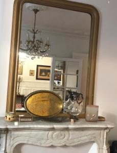 een spiegel bovenop een mantel met een wastafel bij Bel Appartement Haussmannien - Gare de Lyon in Parijs