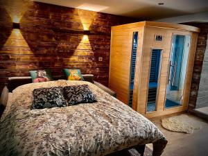 sypialnia z łóżkiem i drewnianą ścianą w obiekcie Le Garden & SPA w mieście Compiègne