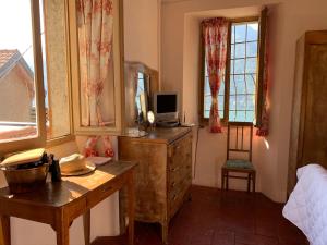 ein Schlafzimmer mit einer Kommode und einem Schreibtisch mit einem Spiegel in der Unterkunft Apartment Casa Dono Il lago in Pognana Lario