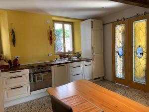 eine Küche mit einem Holztisch und Buntglasfenstern in der Unterkunft Apartment Casa Dono Il lago in Pognana Lario