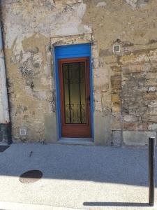 a door with a blue frame on a stone building at Gîte Manapany in Fains-les-Sources