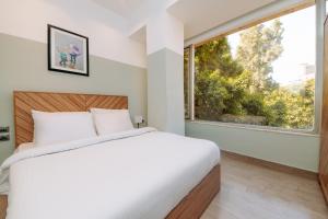 a bedroom with a white bed and white walls at Brassbell at Zamalek in Cairo
