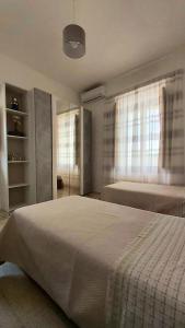 a bedroom with a large bed and two windows at Masseria Parco delle Casette in Alberobello