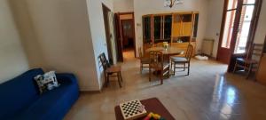 ein Wohnzimmer mit einem blauen Sofa und einem Tisch in der Unterkunft Marchesana Terme - Holiday Home - Family in Terme Vigliatore