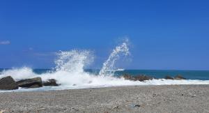 Eine Welle bricht an einem Strand mit Felsen und Wasser in der Unterkunft Marchesana Terme - Holiday Home - Family in Terme Vigliatore