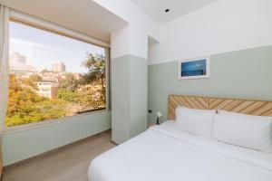 a bedroom with a white bed and a large window at Brassbell apartments in Zamalek in Cairo
