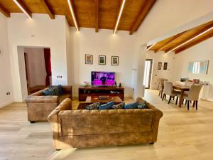 New entire villa with pool and sea views في Santa Domenica Talao: غرفة معيشة مع كنبتين وتلفزيون
