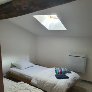 1 dormitorio con 2 camas y tragaluz en Gîte Manapany, en Fains-les-Sources