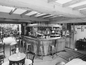 a black and white photo of a bar in a restaurant at Llandudno apartment, quirky pub with tropical beer garden in Llandudno