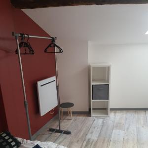 a room with a red wall and a table and a chair at Gîte Manapany in Fains-les-Sources