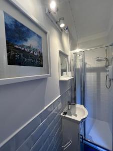 a bathroom with a sink and a painting on the wall at The Stag Hut in Milton