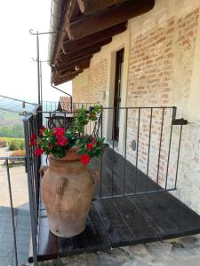 Un jarrón grande con flores en él sentado en un porche en Sul Bric Dei Capalot, en La Morra