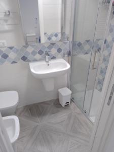 ein Bad mit einem Waschbecken, einer Dusche und einem WC in der Unterkunft U' Pastus in Bari