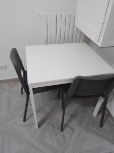 einen weißen Tisch und einen schwarzen Stuhl in einem Zimmer in der Unterkunft U' Pastus in Bari