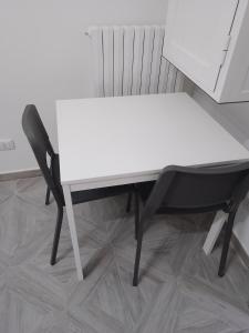 uma mesa branca e uma cadeira preta num quarto em U' Pastus em Bari mais 1 fotografia