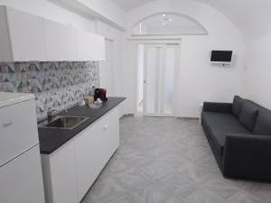 eine Küche mit Sofa und Waschbecken in einem Zimmer in der Unterkunft U' Pastus in Bari