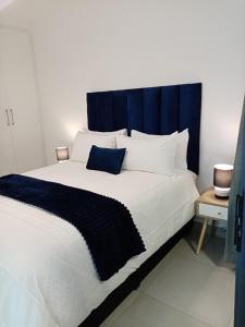a bedroom with a large bed with a blue headboard at Villa 86, Ballito in Ballito