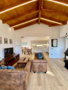 New entire villa with pool and sea views في Santa Domenica Talao: غرفة معيشة كبيرة مع أريكة وبيانو